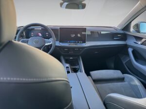 Innenansicht eines modernen Autos mit hellem Leder und großem Touchscreen-Display.