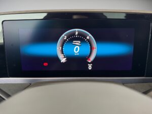 Digitales Fahrzeug-Display mit Tachometer und Warnleuchte, blau-schwarzes Farbschema.