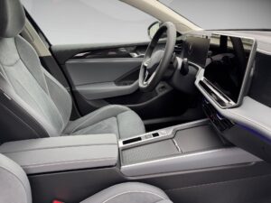 Innenraum eines modernen Autos in grauen Tönen mit großem Display und eleganten Sitzen.