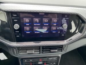 Touchscreen im Auto, zeigt Symbole für Radio, Navigation, Klang; schwarze Umrandung.