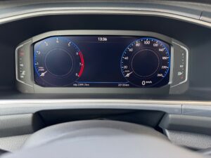 Nahaufnahme eines Auto-Dashboards mit zwei analogen Anzeigen und digitaler Geschwindigkeit.