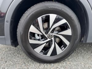 Nahaufnahme eines VW-Rads mit schwarz-silbernem Felgendesign, Ventus Prime3-Reifen auf Kieselsteinen.