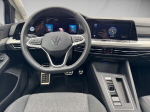 Innenraum eines VW-Autos mit moderner Armaturentafel, schwarzem Lenkrad und digitalen Anzeigen.